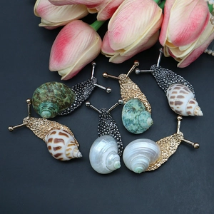Natural seashell and metal snail brooches in gold and silver finishes with shell inlay