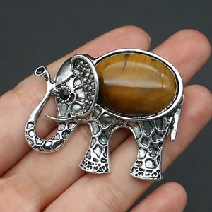 Detailed close-up of elephant brooch with tiger eye stone and silver mesh texture