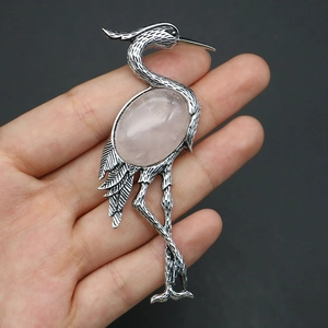 Detail of vintage silver crane brooch with large oval pink quartz stone inlay