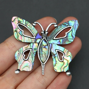 Detailed view of handmade butterfly brooch with natural abalone shell in silver frame