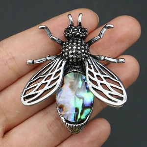 Gros plan sur une broche insecte vintage en argent avec incrustation d'abalone