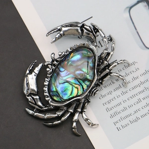 Vintage silver crab brooch with iridescent abalone shell inlay on a stylish background