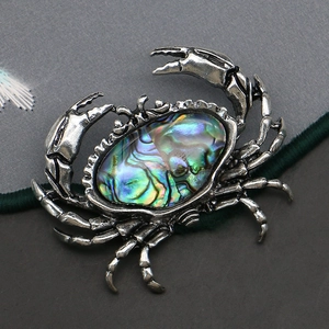 Exquisite crab brooch featuring vibrant abalone shell inlay and vintage metal textures