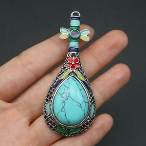 Macro d'un pendentif luth argenté avec pierre turquoise et détails d'incrustation en émail