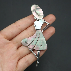 Close-up of elegant dancer brooch with iridescent mother-of-pearl shell inlay on silver metal