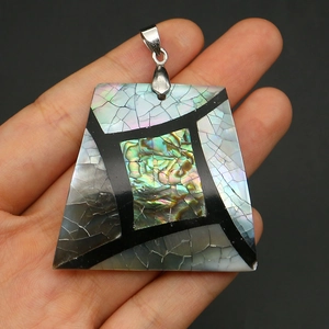 Macro detail of trapezoid abalone shell pendant with iridescent mosaic inlay and metal bail