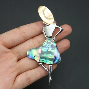 Detailed close-up showing the shimmering abalone shell textures of the vintage dancer brooch