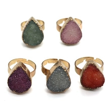 Lot de cinq bagues en cristal en forme de goutte en vert, rose, violet, gris et rouge