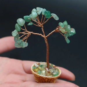 Detailed macro view of a miniature green crystal tree held in a small hand