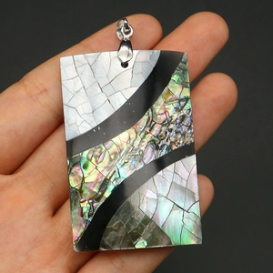 Macro detail of rectangular abalone shell pendant with rainbow sheen and silver clasp
