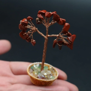 Close-up of a handmade mini gemstone tree with red crystals in a small woven basket