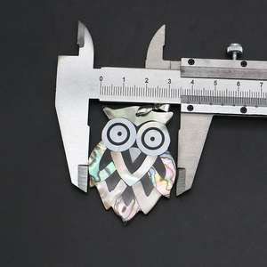 Mesure au pied à coulisse montrant la largeur de 32 mm du pendentif hibou en nacre