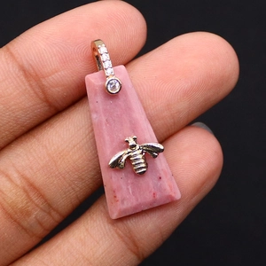 Detalle macro del colgante de rodonita rosa con abeja dorada y cierre con circonitas