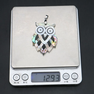 Pendentif hibou en nacre sur balance numérique affichant un poids de 12,93 grammes