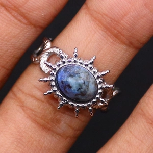 Macro shot of vintage stainless steel sunflower ring with a blue oval natural stone inlay