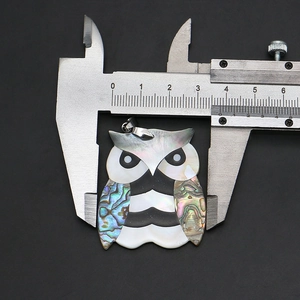 Vue détaillée du pendentif chouette en nacre montrant une largeur de 3,8 cm au pied à coulisse