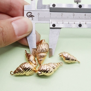 Détail d'un pendentif coquillage doré de 15mm mesuré avec un pied à coulisse numérique