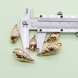 Macro montrant la largeur exacte de 10 mm du pendentif coquillage doré pour bijoux DIY