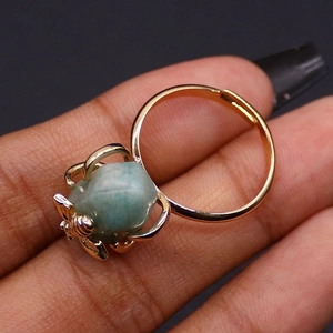 Close-up of gold bee claw ring featuring natural light blue stone on black background
