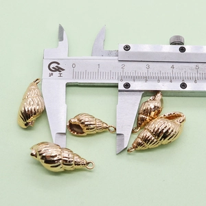 Gros plan d'un pendentif coquillage doré de 18mm avec mesures précises au pied à coulisse