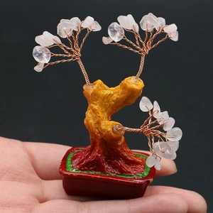 Détail macro d'un mini arbre de fortune en cristal rose avec fil de cuivre et pot rouge