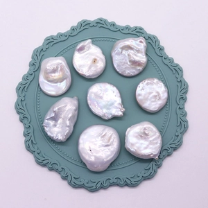 Baroque natural freshwater coin pearls with high luster on a blue vintage textured mat