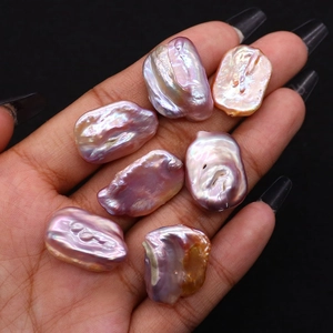 Handheld baroque freshwater pearls with metallic iridescent luster in purple and gold tones