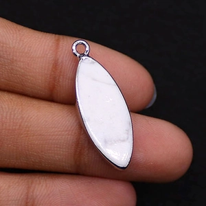 Close-up of a marquise-cut white turquoise stone pendant with silver plated metal edging