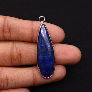 Detail of teardrop lapis lazuli pendant with gold plating and natural blue stone textures