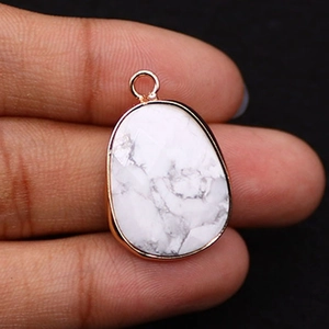 Detailed close-up of oval white marble stone pendant with rose gold plated metal edging