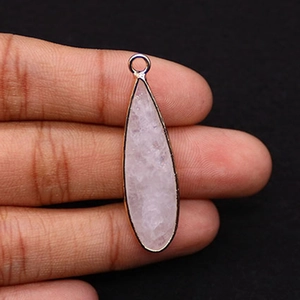 Detail of hand holding a natural rose quartz teardrop pendant with gold-plated metal edging