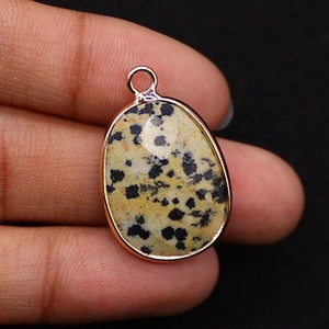 Detail of teardrop Dalmatian stone pendant with rose gold plated bezel and metal loop