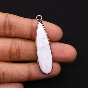 Detailed close-up of a teardrop-shaped white stone pendant with golden metal edges