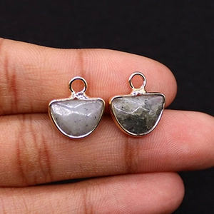Close-up of semi-circle natural stone pendants with gold plated edges and gray textures