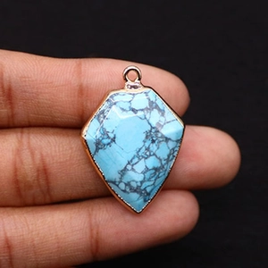 Detailed view of turquoise shield pendant with gold plated edges for DIY jewelry making
