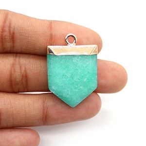 Détail d'un pendentif en pierre naturelle verte en forme de bouclier avec placage d'or