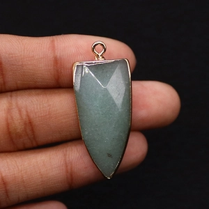 Detailed view of faceted green stone arrowhead pendant with gold-plated metal border