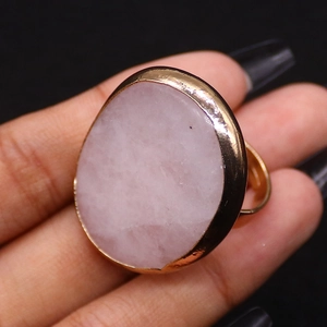 Dettaglio macro di un anello in cristallo rosa naturale con fascia regolabile placcata oro