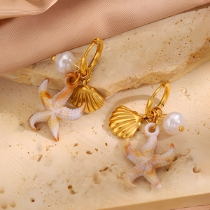 Details goldener Meeres-Ohrringe mit Perlen, Muscheln und Seestern-Anhängern