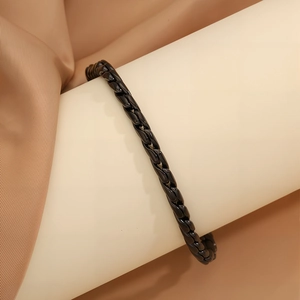 Dettaglio di un bracciale minimalista in acciaio inossidabile nero intrecciato da uomo