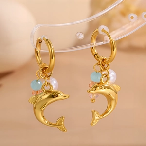 Detailansicht der goldenen Delfin-Ohrringe mit bunten Perlen und Anhängern aus Edelstahl