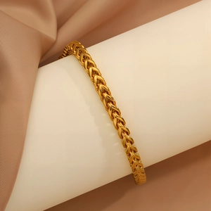 Vista dettagliata del bracciale in acciaio inossidabile dorato con maglie a V a lisca di pesce