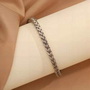 Dettaglio macro del bracciale a catena in argento lucido con design a maglia intrecciata