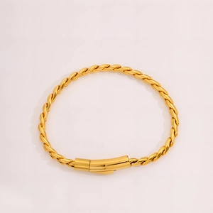Dettaglio del bracciale a catena intrecciata dorata con finitura lucida e chiusura a vite