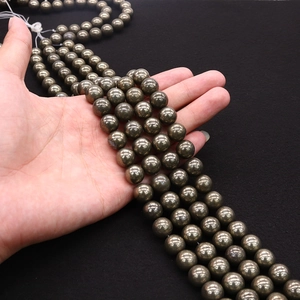 Handheld strands of polished natural pyrite round beads with metallic bronze luster