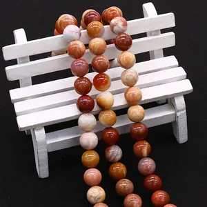 Gepolijste natuursteen kralen op een wit bankje voor het maken van DIY sieraden en kettingen