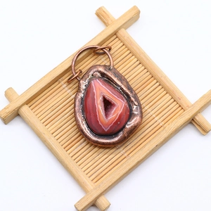 Detailed view of striped natural agate pendant with vintage hammered metal plating edges