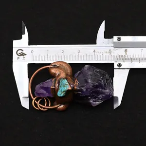 Détail du pendentif en cristal violet et turquoise mesuré avec un pied à coulisse