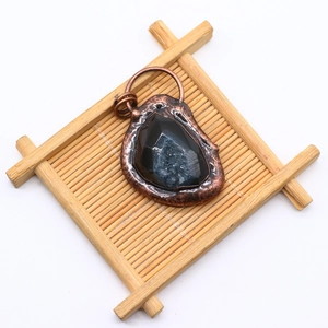 Macro detail of natural stone pendant with copper plated edge on bamboo mat