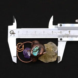 Vue détaillée d'un pendentif en pierre brute fait main avec fil de cuivre et mesure